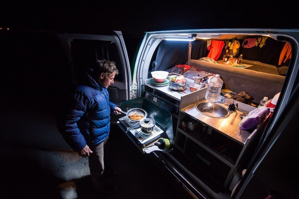 Man Cooking at Campervan Kitchen at Night