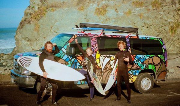 Three Surfers in front of an Escape Campervan in California