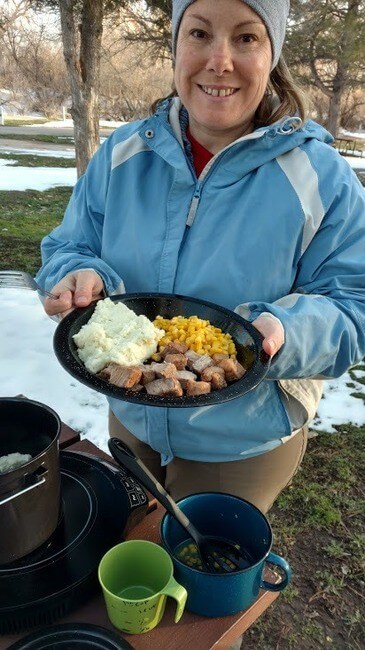 Campervan cooking pork chops, mashed potatoes, corn