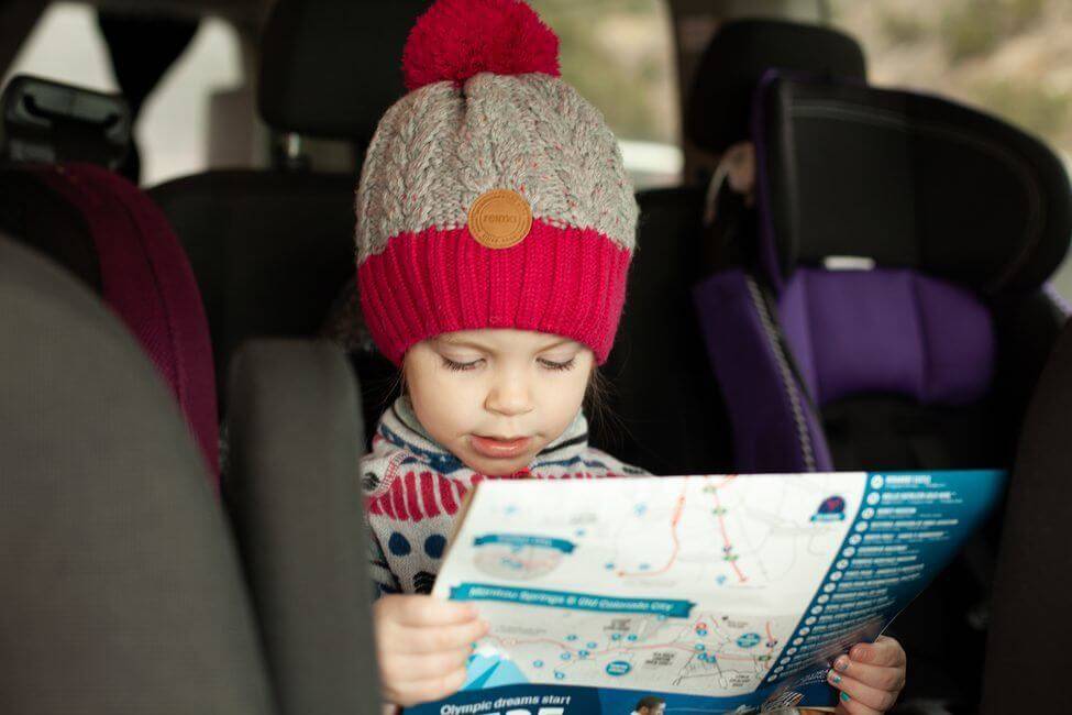 Girl reading map on campervan trip in Colorado