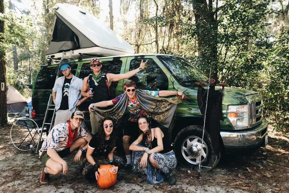 Friends gathered around a campervan