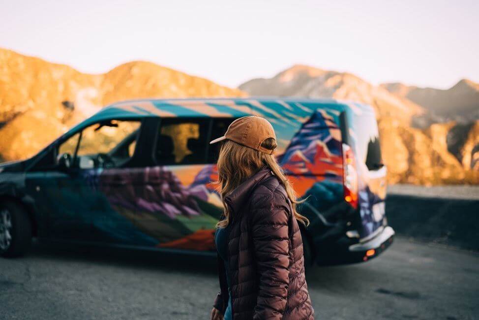 Woman in jacket walking by campervan