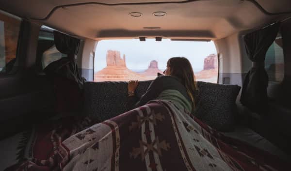 international travelers sleeping in campervan at monument valley