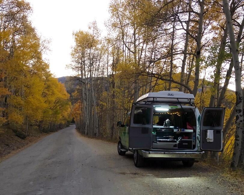 Campervan with kitchen surrounded by fall colors in Colorado