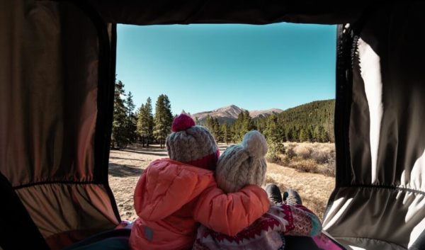 Two girls hugging from inside campervan