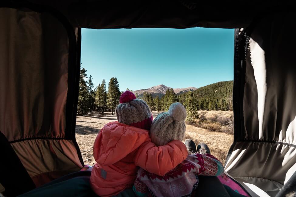 Two girls hugging from inside campervan