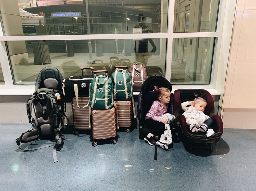 Kids in airport in carseats by luggage