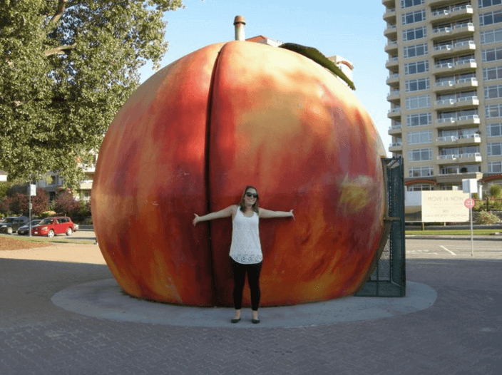 Woman standing in front of a giant peach