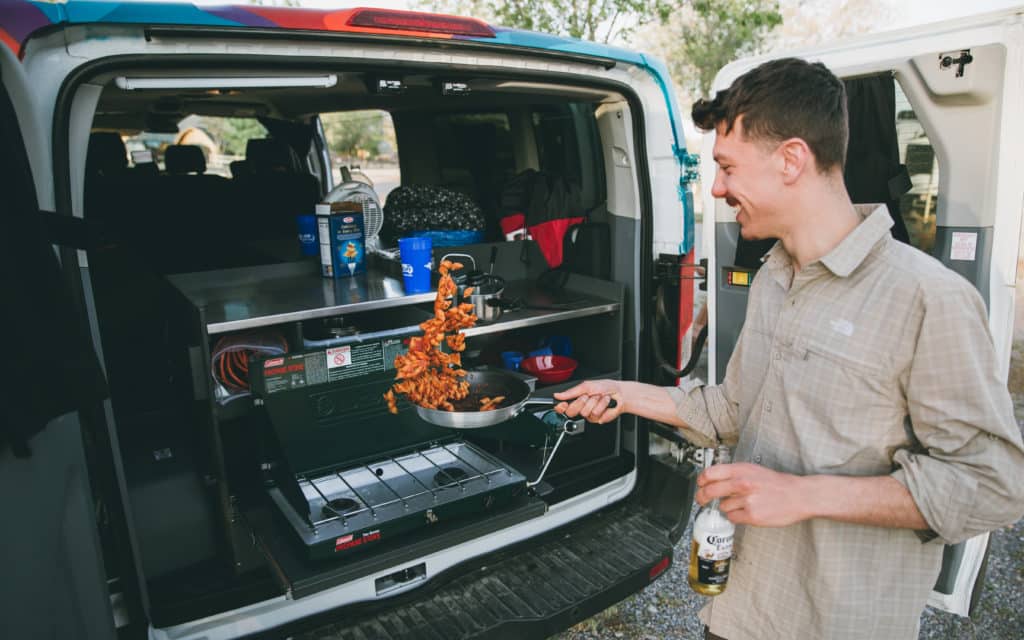 Cooking using the stove in a Big Sur campervan.