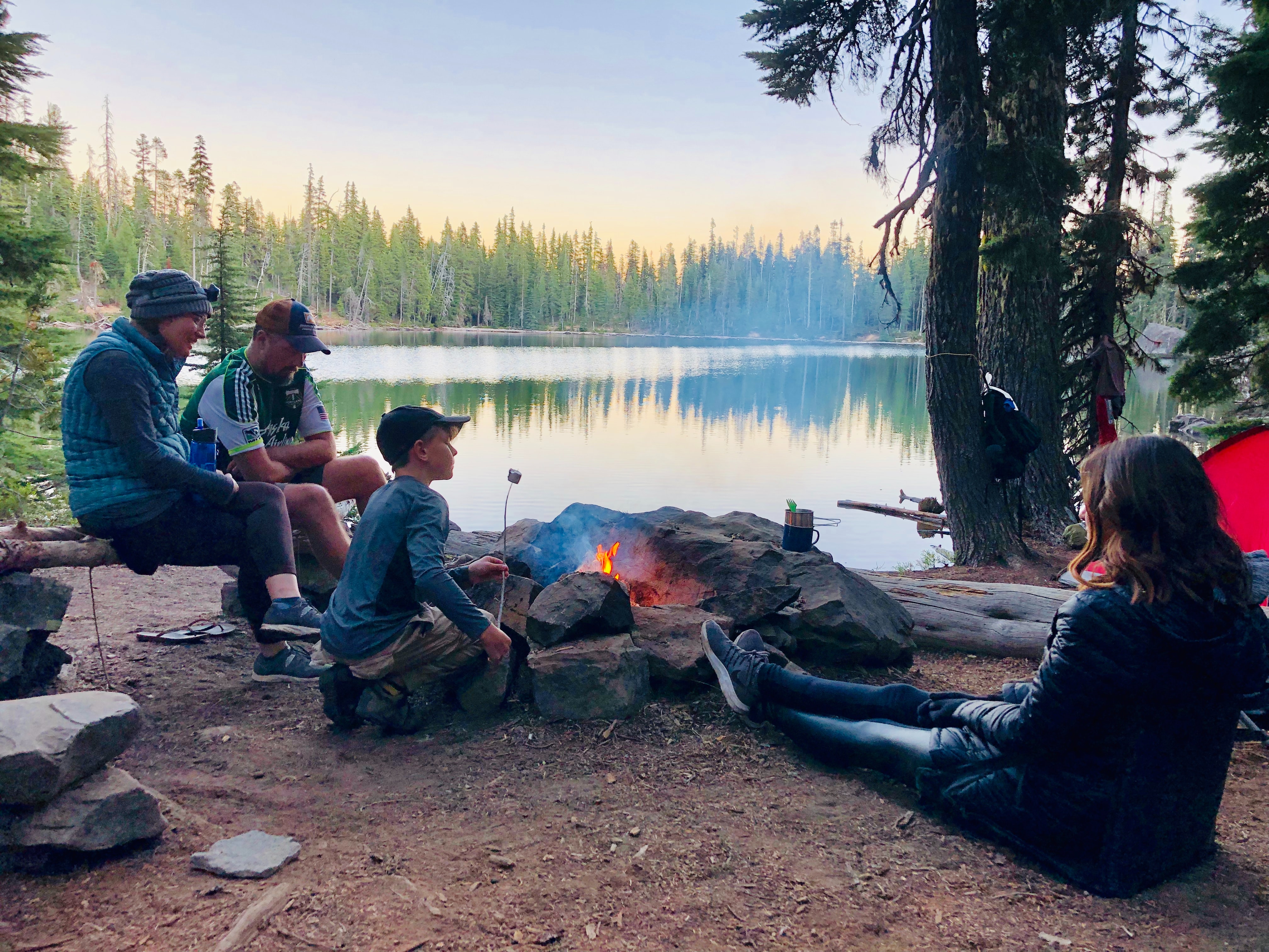 Family sitting around a campfire.