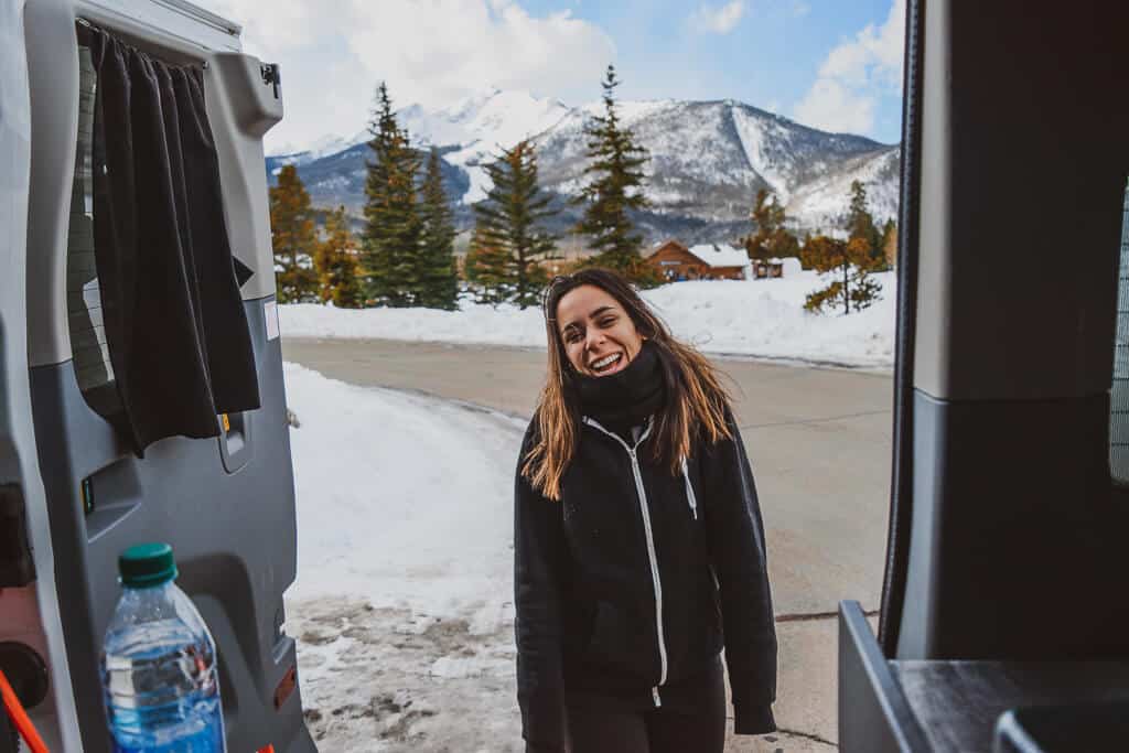 Woman standing behind a camper van
