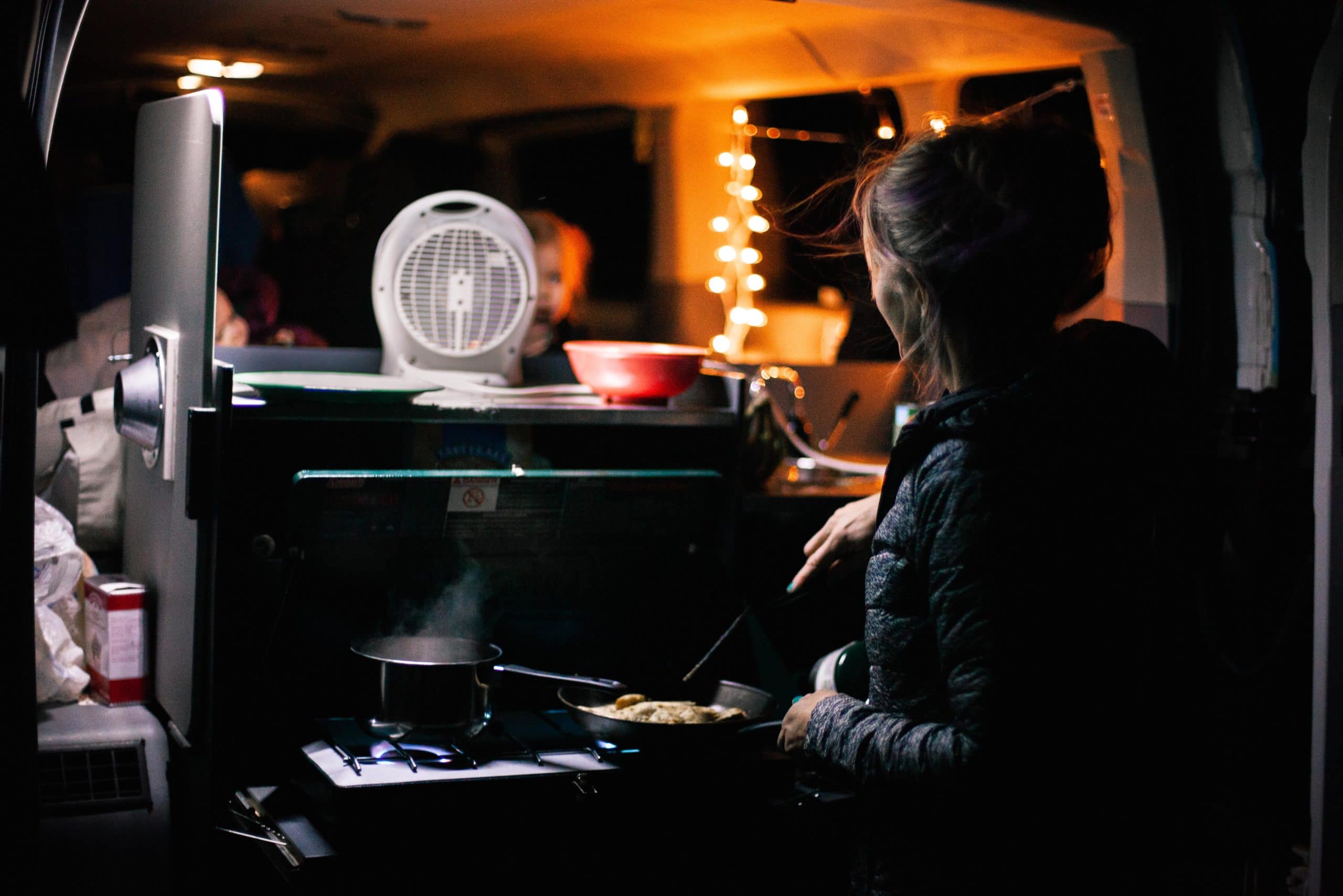 Woman cooking while on a winter road trip