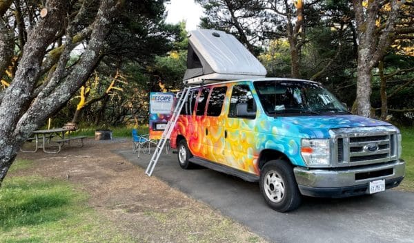 A colorful van at Escape Camper Vans' Portland camper van rental location at Bay State Park.
