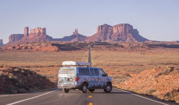 Van parked on the road with Canyonlands National Park in the background